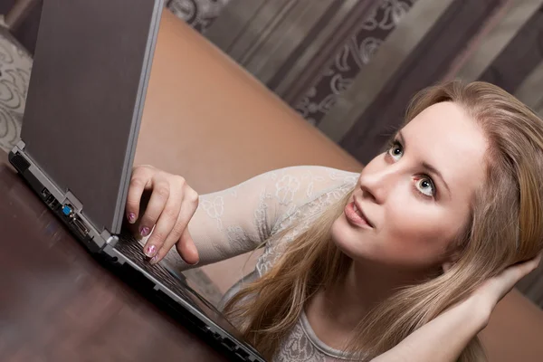 Hermosa chica rubia está trabajando en un ordenador portátil — Foto de Stock