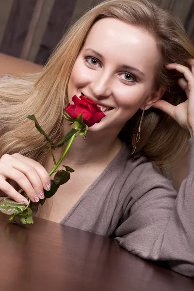 Prachtige blond meisje houdt van een rode roos — Stockfoto