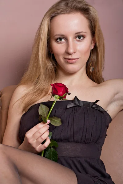 Atractiva joven con una rosa roja — Foto de Stock