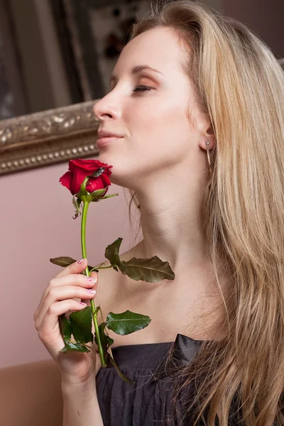 Πανέμορφη ξανθιά γυναίκα με ένα κόκκινο τριαντάφυλλο — Φωτογραφία Αρχείου