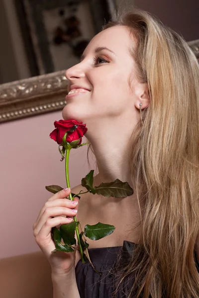 Chica rubia sonriente con una rosa roja — Foto de Stock