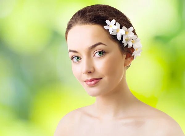 Beautiful woman with flowers in her hair and pure skin — Stock Photo, Image