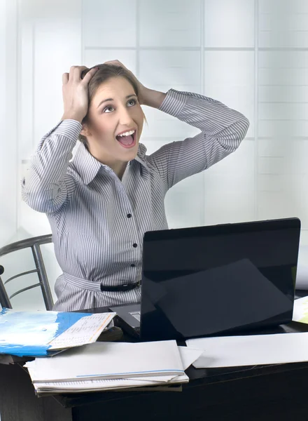 Opgewonden zakenvrouw op kantoor met laptop — Stockfoto