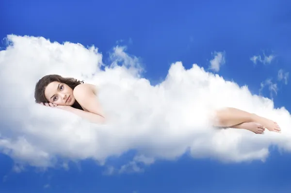 Beautiful woman lying on clouds — Stockfoto