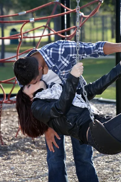 Couple romantique s'embrassant sur une aire de jeux (1 ) — Photo