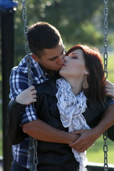 Couple romantique s'embrassant sur une aire de jeux (2 ) — Photo