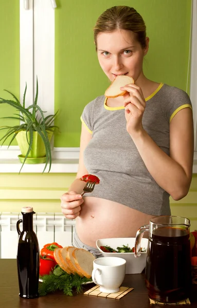 Беременная женщина на кухне — стоковое фото