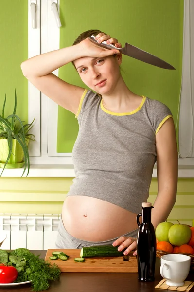 Mulher grávida na cozinha com faca — Fotografia de Stock