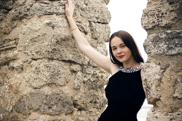 Açık atış eski taş duvara yaz elbiseli genç kadın — Stok fotoğraf