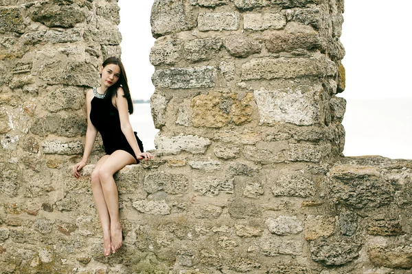 古い石の壁、屋外ショットの夏のドレスの若い女性 — ストック写真