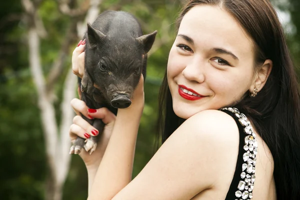 黒豚を持つかなり若い女性 — ストック写真