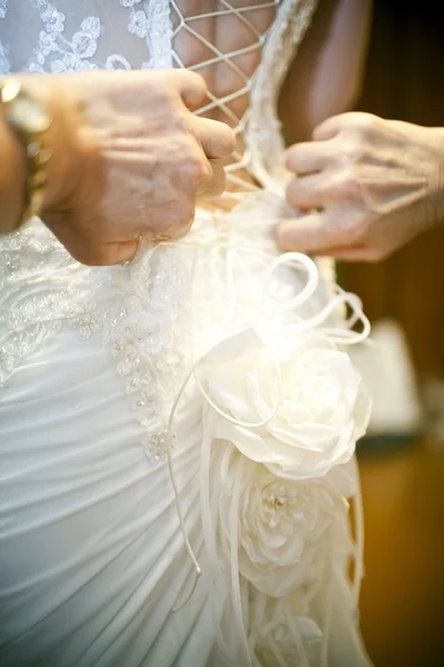 Las manos femeninas que aprietan el corsé a la novia — Foto de Stock