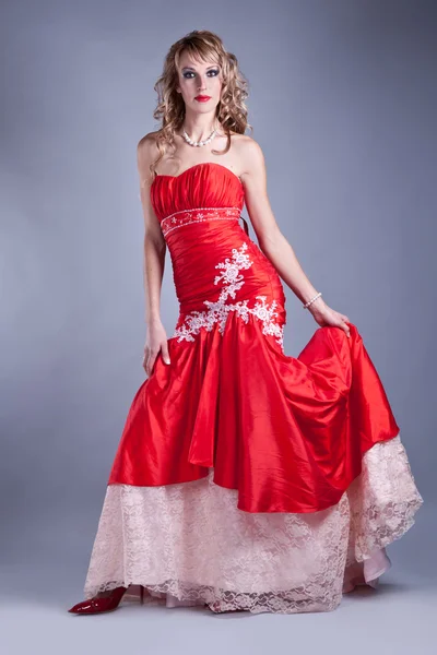 Mooie vrouw in rode jurk Stockfoto