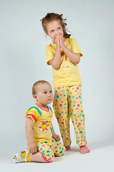 Twee leuke meisjes in gele pyjama 's — Stockfoto