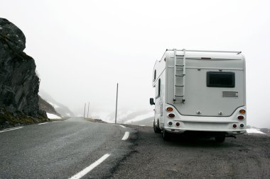 Motorhome in misty mountainous terrain clipart