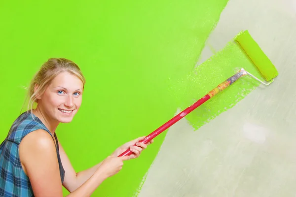 Женщина рисует зеленую стену — стоковое фото