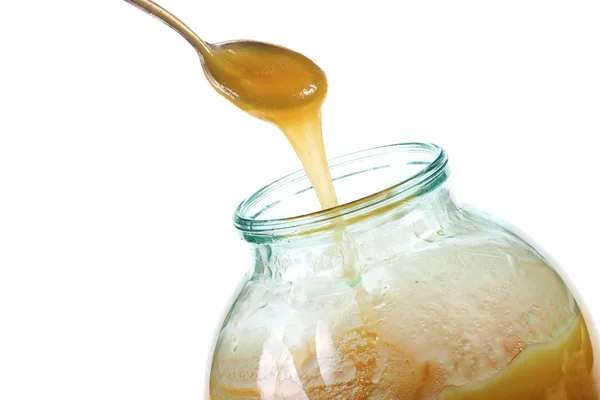 Taking the honey with a spoon from the jar — Stock Photo, Image