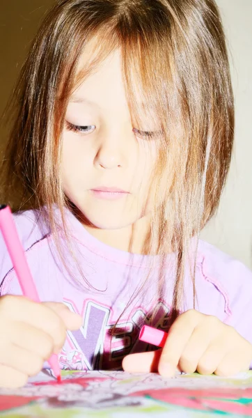 Girl decorates marker drawings in the book — Stock Photo, Image