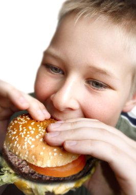 Young boy eating cheeseburger clipart