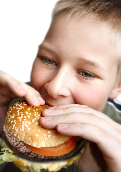 Niño comiendo hamburguesa con queso —  Fotos de Stock