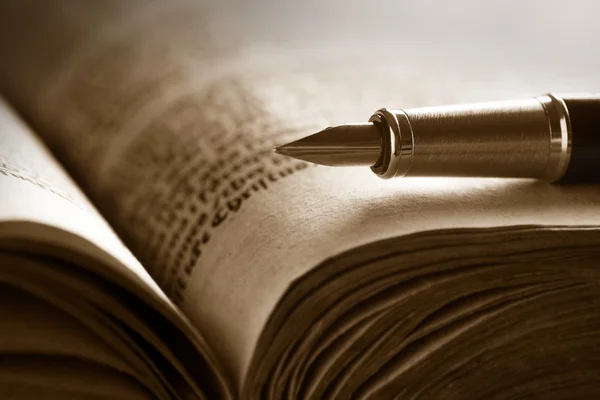 Старая книга и ручка — стоковое фото