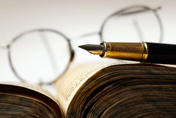 Старая книга и ручка — стоковое фото