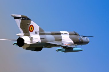 MiG 21 Romanian fighter aircraft isolated over blue sky clipart