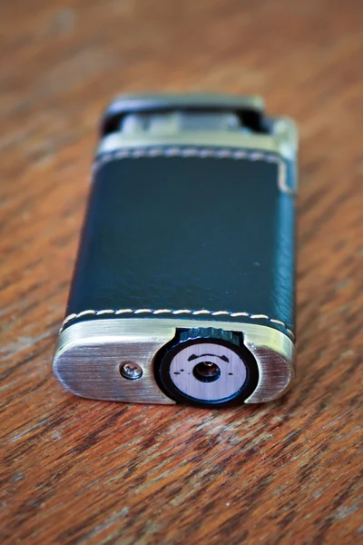 Old cigarette lighter dressed in leather on the table — Stock Photo, Image