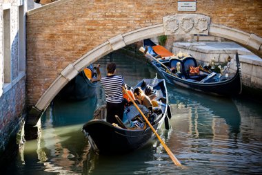 Tourists traveling on gondola on Venice canals clipart