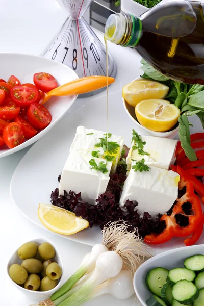 Mediterraner Salat auf weißem Tisch mit Olivenöl — Stockfoto