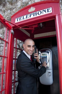 Business Man on the public phone clipart