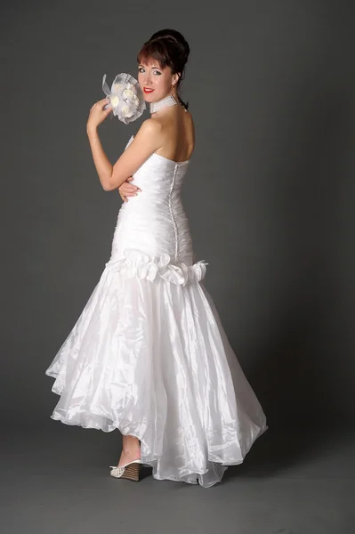 Jonge vrouw in jurk bruid met boeket in studio — Stockfoto