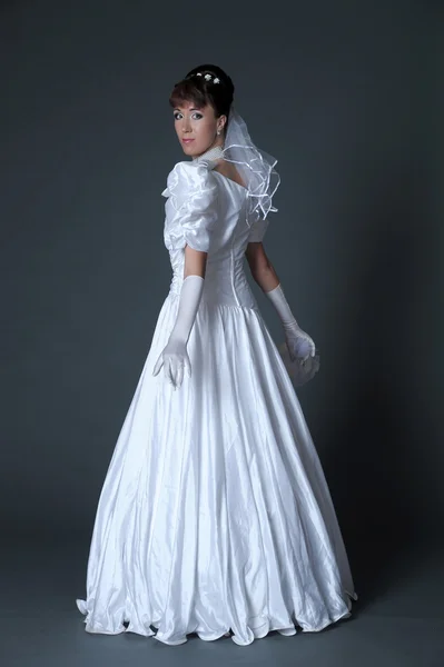 Mujer joven en vestido de novia con ramo en el estudio — Foto de Stock