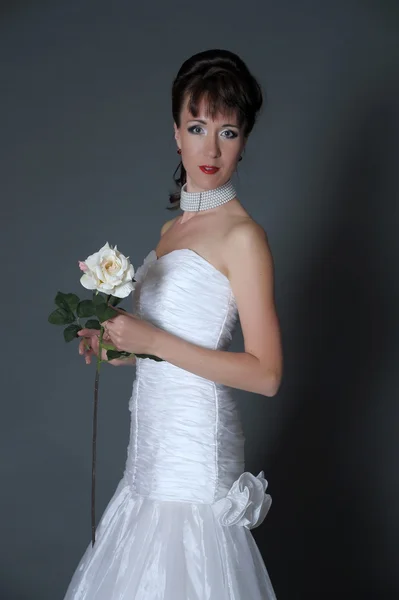 De gelukkige bruid met een witte roos — Stockfoto