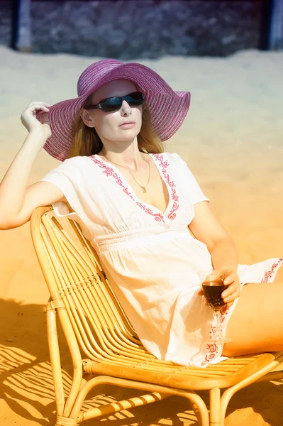 Pláž - mladá žena sedí na lehátku — Stock fotografie
