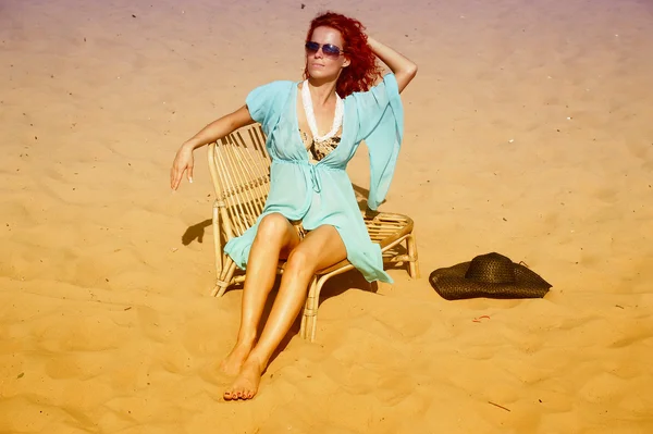 Mladá žena sedí na pláži — Stock fotografie