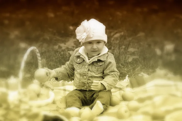 Malá holka sedí s košem jablek — Stock fotografie