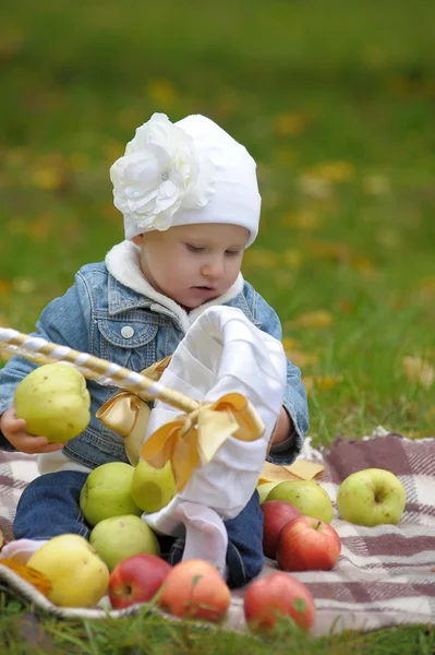 Niña sentada con una cesta de manzanas — Foto de Stock