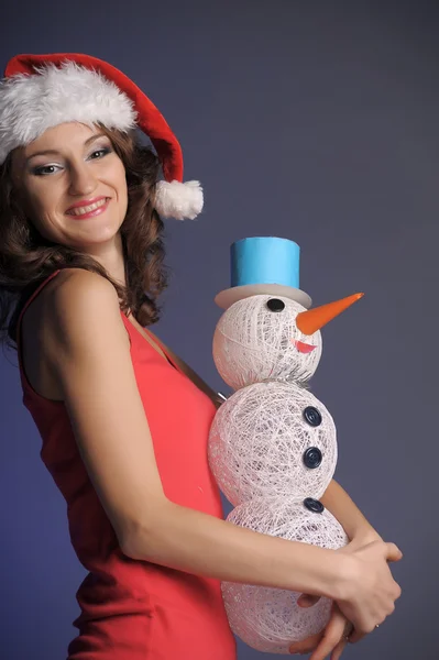 Jeune femme avec un bonhomme de neige — Photo