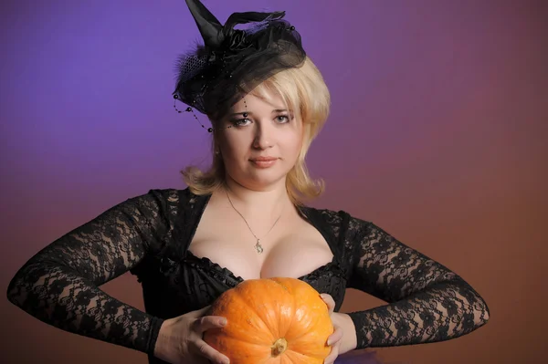 Portrait of a young witch holding a pumpkin — Stock Photo, Image