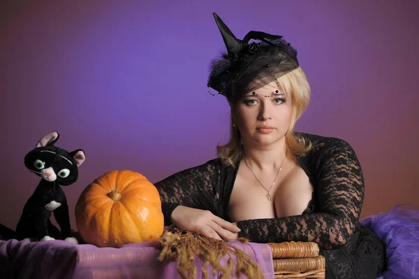 Retrato de una joven bruja sosteniendo una calabaza — Foto de Stock