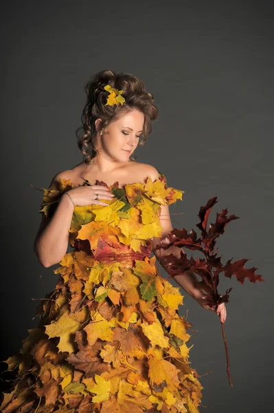 Жінка в сукні з осіннього листя — стокове фото