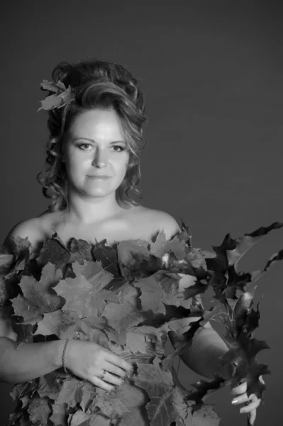 Женщина в платье из осенних листьев — стоковое фото