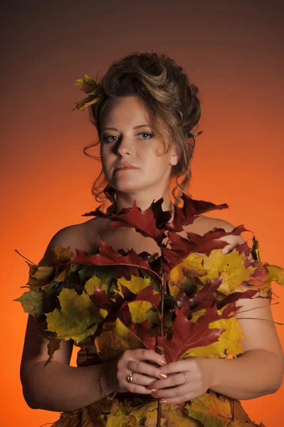 Žena v šatech z podzimní listí — Stock fotografie