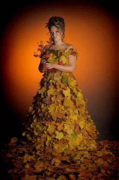 Жінка в сукні з осіннього листя — стокове фото