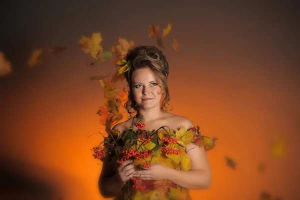 The woman in a dress from autumn leaves — Stock Photo, Image