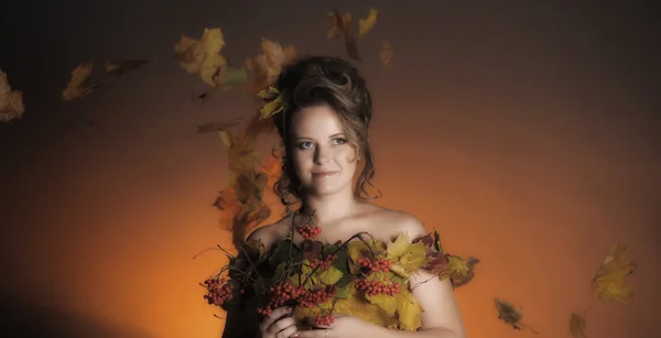 A mulher em um vestido de folhas de outono — Fotografia de Stock