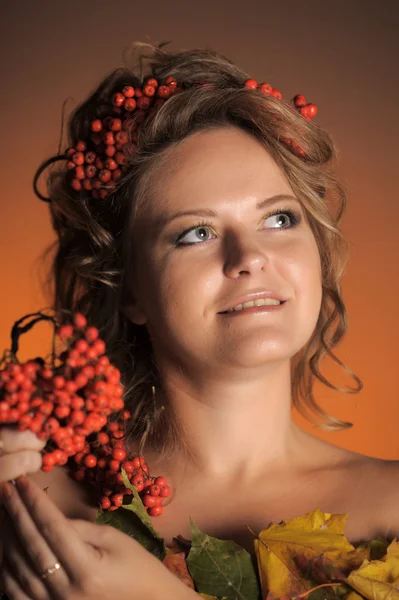 Beautiful girl holds a branch of a mountain ash — Stock Photo, Image