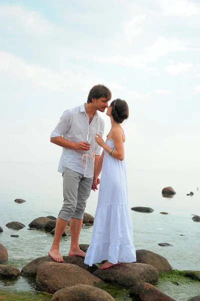 Romantikus pár gazdaság kezek & Csókos a strandon — Stock Fotó