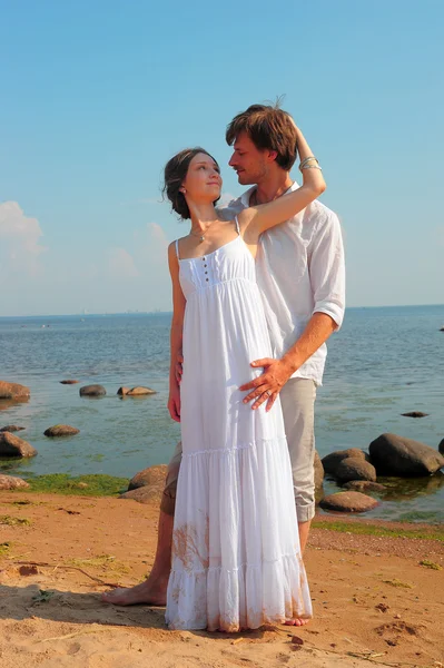 Pareja romántica sosteniendo las manos y besándose en una playa — Foto de Stock